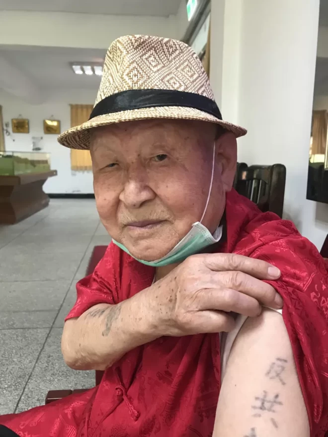 팔에 새겨져 있는 반공 문신을 보여주는 남성