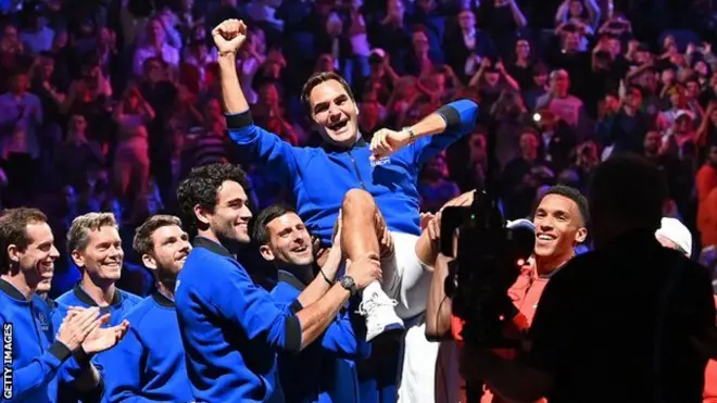 Roger Federer dey lifted up by im team-mates for di O2 Arena for London