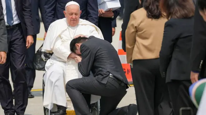 پاپ فرانسیس و مردی در حال بوسیدن دست او