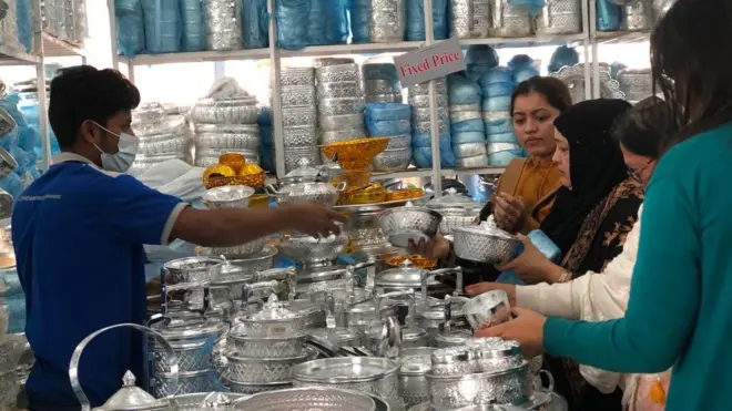 পূর্বাচলে বাণিজ্য মেলায় পণ্য দেখছেন কয়েকজন ক্রেতা