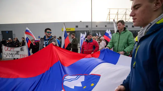 Manifestantes sostienen la bandera eslovena.