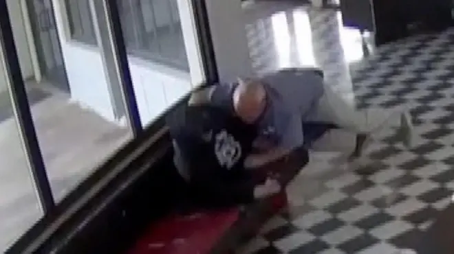 Hombre deteniendo a otro hombre con su cuerpo y brazos