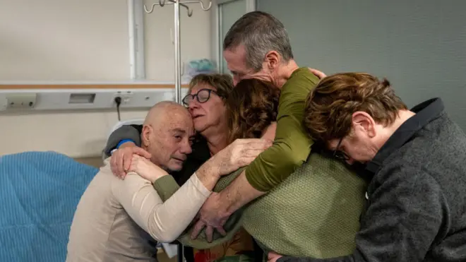 Luis Har (izquierda) y Fernando Marman (con camiseta verde y cabello gris) abrazan a varios familiares tras su rescate.