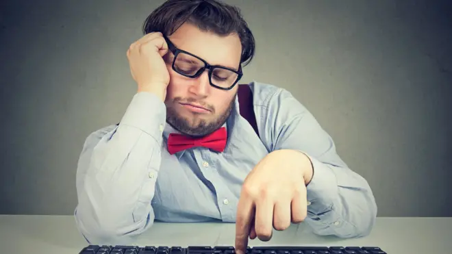 Hombre con teclado de ordenador siendo perezoso.