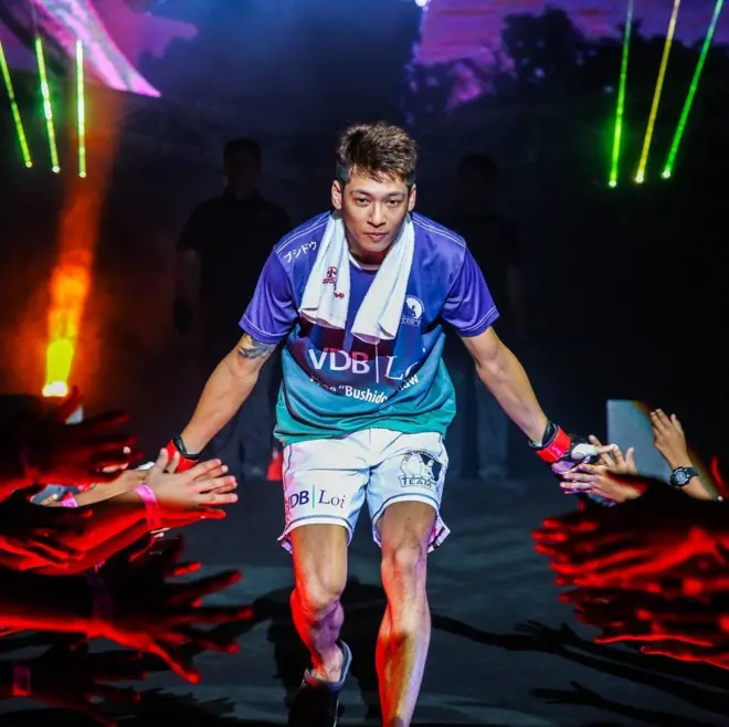 MMA ပွဲတစ်ခုမှာ အထွက်မှာ ပရိသတ်ကို နှုတ်ဆက်နေတဲ့ ဖိုးသော်