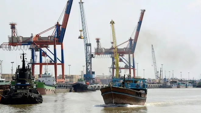 یک قایق باری با پرچم ایران در حال حرکت در رودخانه اروندرود در نزدیکی خرمشهر؛ این رودخانه مرز میان ایران و عراق را تشکیل می‌دهد.