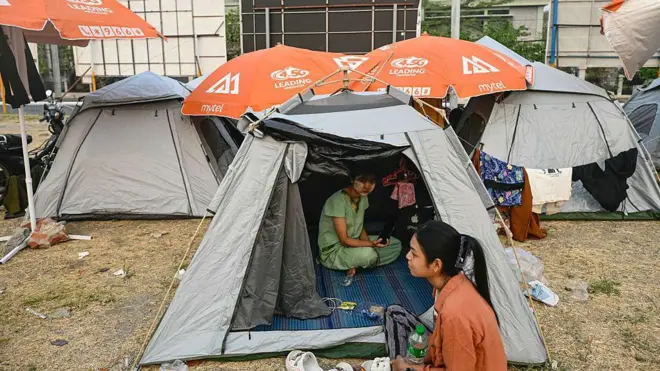 Dua perempuan mengungsi di perkemahan tenda sementara