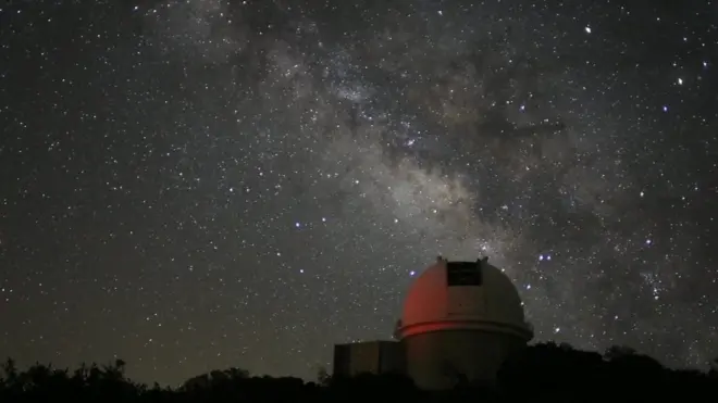 กล้องโทรทรรศน์ ฉากหลังเป็นท้องฟ้าตอนกลางคืน