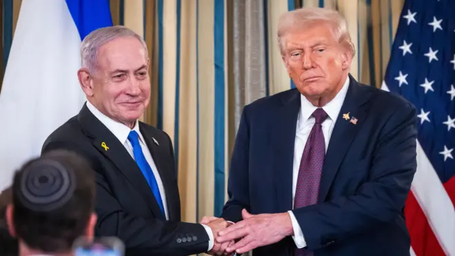 Benjamín Netanyahu y Donald Trump se estrechan las manos mientras posan para los medios