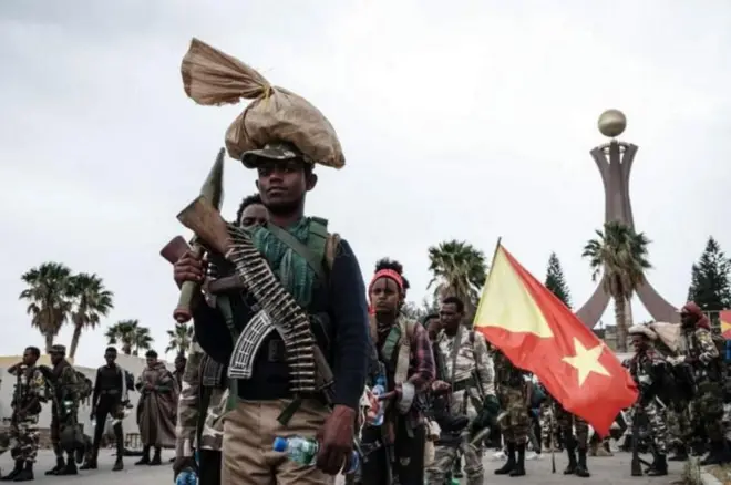 ሓይልታት ትግራይ ባንዴራ ሒዞም እናተጓዓዙ፣ ሓወልቲ ሰማእታት መቐለ ብድሕሪኦም ይርአ።