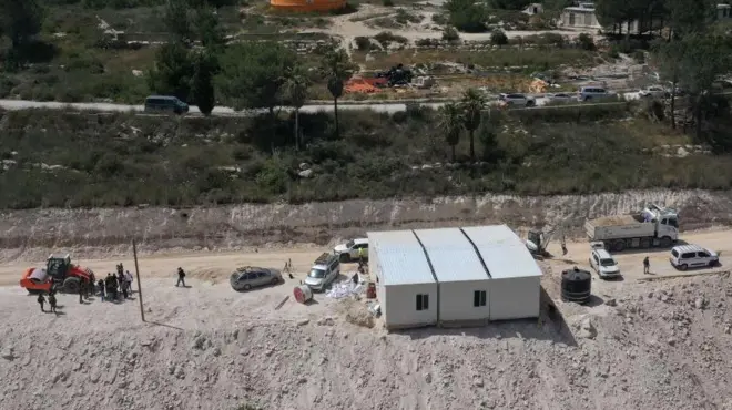Una vista aérea muestra a personas alrededor de un edificio portátil en construcción en el asentamiento ilegal israelí de Homesh, cerca de la aldea palestina de Burqa, en la Cisjordania ocupada (29 de mayo de 2023).