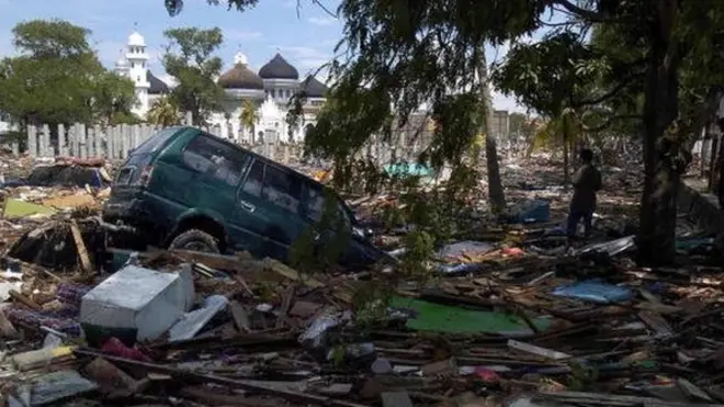 Puing bangunan, gelondongan kayu, hingga mobil berserakan di sekitar Masjid Agung Baiturrahman setelah tsunami melanda Aceh tahun 2004 lalu