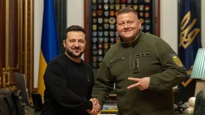 Володимир Зеленський тисне руку Валерію Залужному. Обоє дивляться в камеру і посміхаються