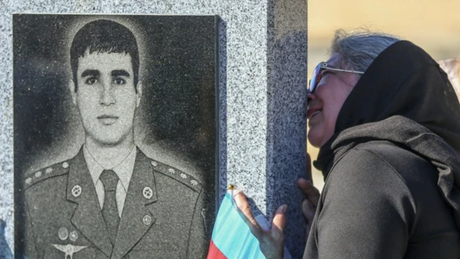 زنی بر سنگ قبر یکی از نظامیان آذربایجانی کشته شده در درگیری بر سر منطقه قره باغ بوسه می‌زند