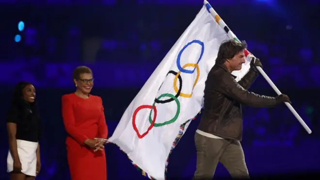 जिम्नास्ट सिमोन बायल्स लॉस एंजेलिस की मेयर कैरेन बास और अभिनेता टॉम क्रूज़ (बाएं से दाएं)