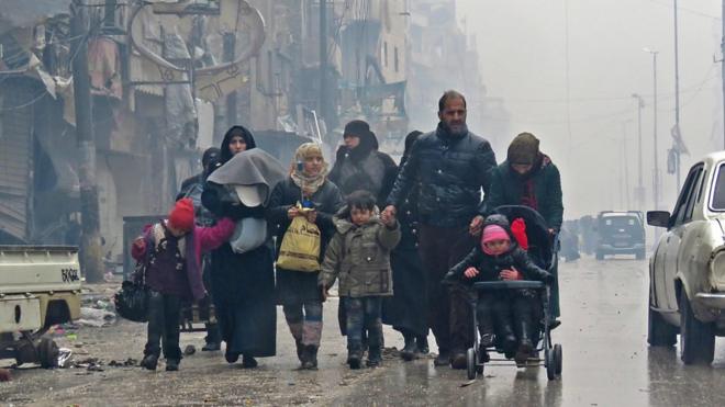 Una familia camina por una calle de Alepo