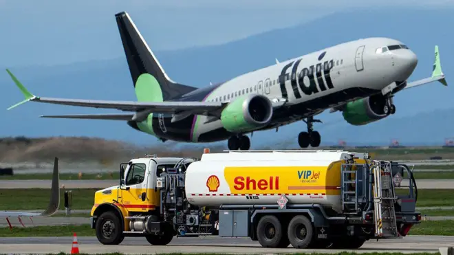 Avión volando sobre un camión cisterna