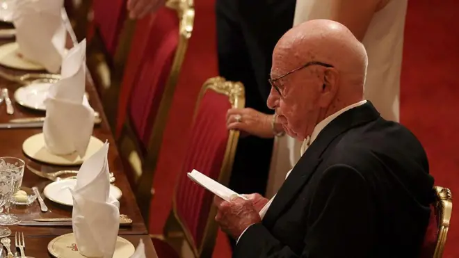 مرداک در یک ضیافت، کاغذی در دست دارد و به آن نگاه می‌کند