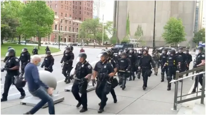 Still image from video of elderly man being pushed by police