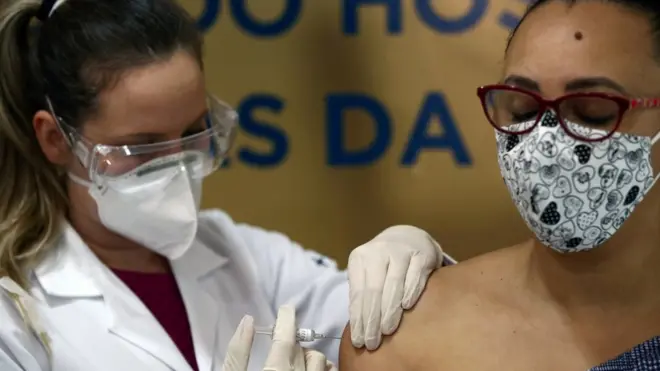 A nurse administers China's Sinovac vaccine to a volunteer at the Sao Lucas Hospital of the Pontifical Catholic University of Rio Grande do Sul (PUCRS), in Brazil, 8 August, 2020.