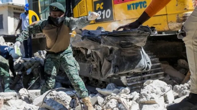 Soldiers and members of a rescue and protection team clean debris from a house after a 7.2 magnitude earthquake in Les Cayes, Haiti August 15, 2021.