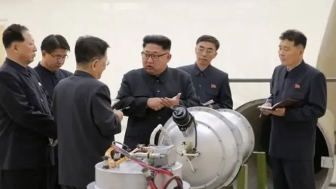 උතුරු කොරියාවේ නායක කිම් ජොන් අන් නය්ෂ්ඨික බෝම්බයක ආකෘතියක් සමග