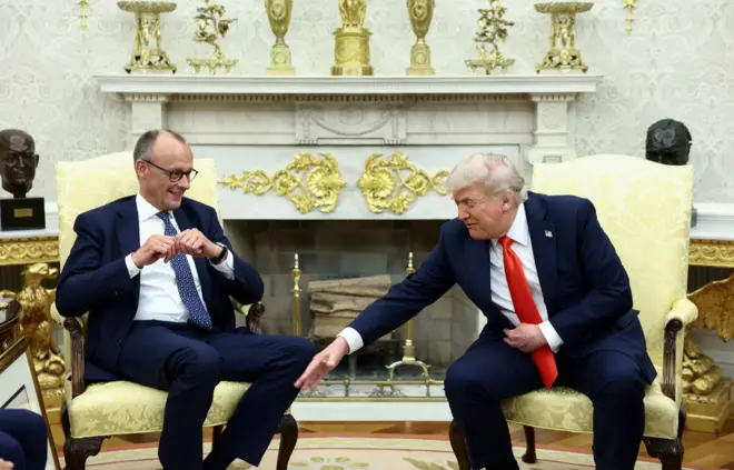 Трамп тянет руку к колену Мерца, Мерц улыбается