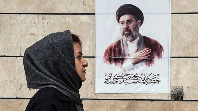 Bir başörtülü kadın, İran lideri Hamaney'in fotoğrafının önünden geçiyor