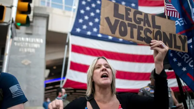 Seorang pendukung Presiden Donald Trump membawa plakat menyerukan agar "suara sah" saja yang dihitung.