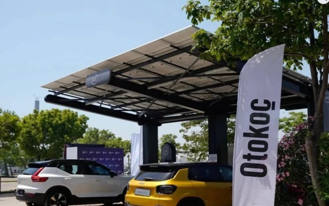 Otokoç yazılı bir park yerinde iki yeni araba duruyor.