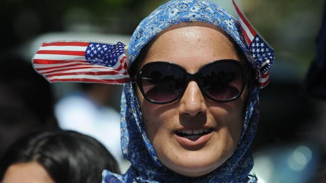 Una mujer con velo y banderitas de EEUU