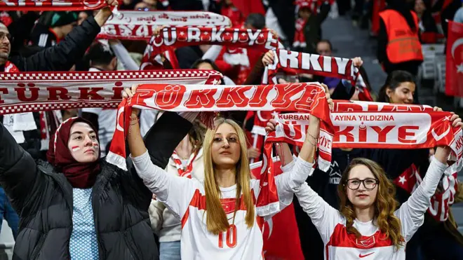Kadın izleyiciler türkiye atkılarını gösteriyor. 