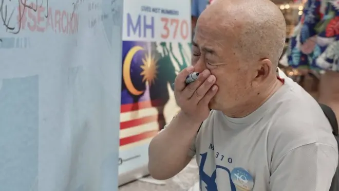 Mr Li weeps after writing a message to his son