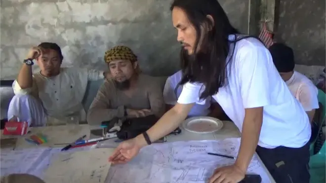 Abdullah Maute (berdiri) menunjuk peta dalam pertemuan dengan Isnilon Hapilon (kedua dari kiri), yang merupakan pemimpin kelompok Abu Sayyaf. Foto ini didapat militer Filipina.