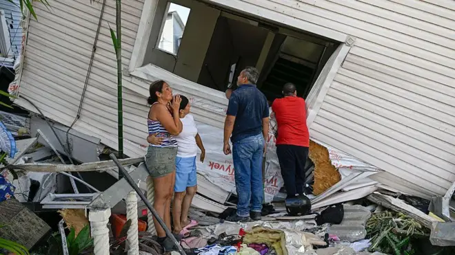 Familia viendo daños en una casa