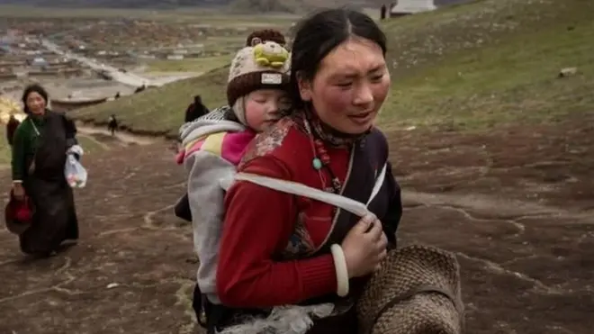 వీపు మీద చిన్నారితో ఓ మహిళ