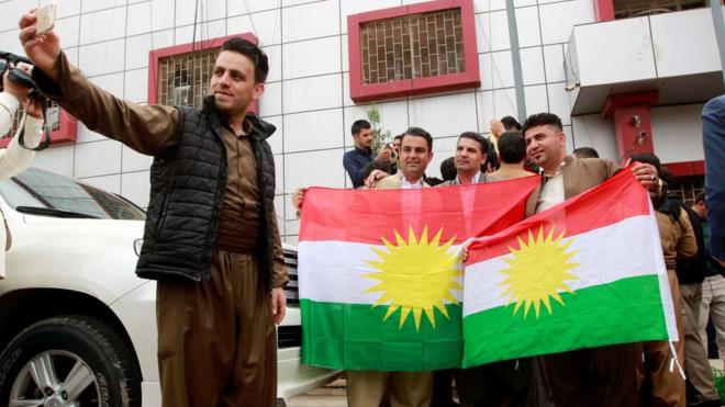 Kurds take pictures with Kurdish flags at the Kirkuk Governorate Council building in Kirkuk, Iraq (6 April 2017)
