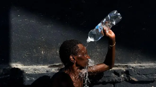 Homem se refresca com garrafaanalise e prognostico futebolágua no Rioanalise e prognostico futebolJaneiro 