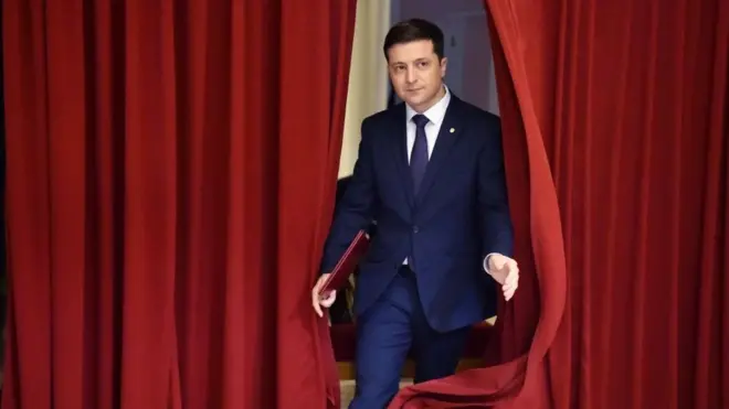 Сцена із серіалу "Слуга народу" в 2019 році, де герой Володимира Зеленського викриває корупцію і брехню можновладців.