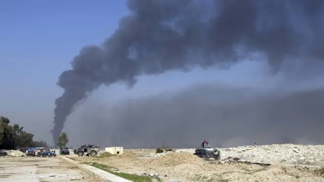 ألسنة الدخان تتصاعد من مطار الموصل الدولي الذي استعادته القوات العراقية من أيدي تنظيم الدولة الإسلامية.