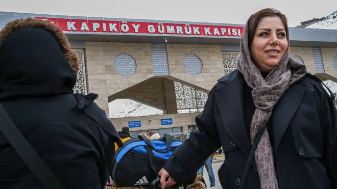 İran ve Türkiye arasındaki Kapıköy Gümrük Kapısı önünde bir kadın valizini çekerken