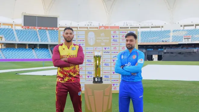 راشد خان او د وېسټ انډيز لوبډلمشر له ټرافۍ سره ولاړ دي