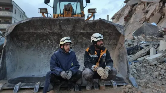 Des secouristes fatigués prennent une pause.