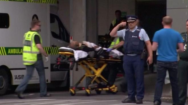 Emergency services personnel transport a stretcher carrying a person at a hospital in central Christchurch, New Zealand
