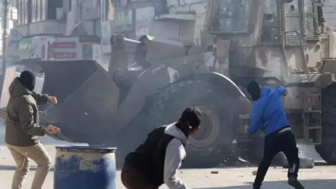 فلسطينيون يقذفون جرافات إسرائليية بالحجارة أثناء اقتحام جنين في الضفة الغربية