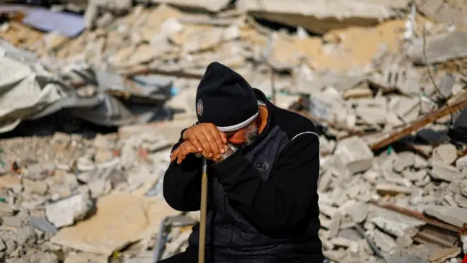 Zijad Mansur, komšija nastradale porodice u Rafi, na jugu Pojasa Gaze, sedi usred ruševina porodične kuće, koja je uništena u smrtonosnom izraelskom napadu