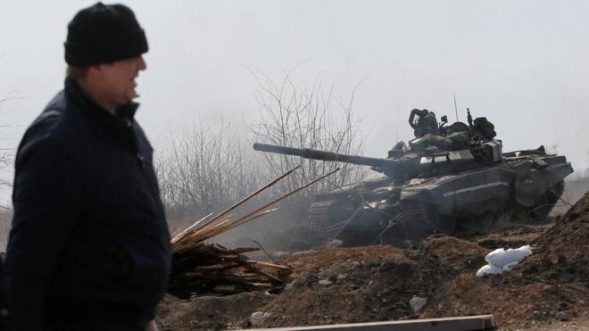 烏克蘭馬里烏波爾一位男子走過被焚毀的親俄武裝部隊坦克（20/3/2022）