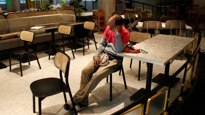 A delivery man waits for orders to pick up at a restaurant open only for take away and delivery, after the government started opening some restaurants outside shopping malls, parks, and barbershops during the coronavirus disease (COVID-19) outbreak in Bangkok, Thailand, May 3, 2020