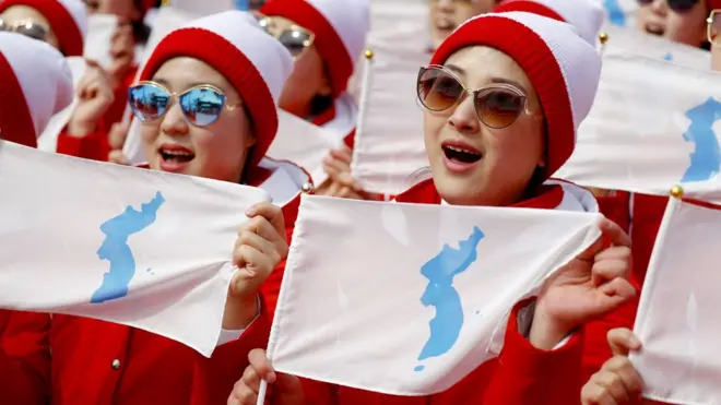 Animadoras norcoreanas con la bandera de la "Corea unificada"