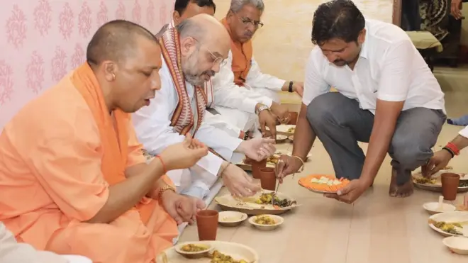 सोनू यादव के घर पर खाना खाते मुख्यमंत्री योगी आदित्यनाथ और बीजेपी अध्यक्ष अमित शाह